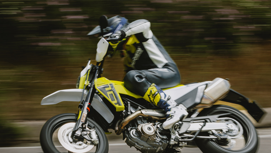 Vue latérale dynamique de la Husqvarna 701 Supermoto 2026 sur route.