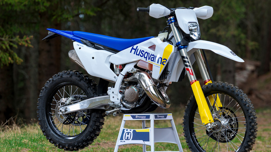 Vue latérale dynamique de la Husqvarna TE 125 2026 sur un terrain d’enduro