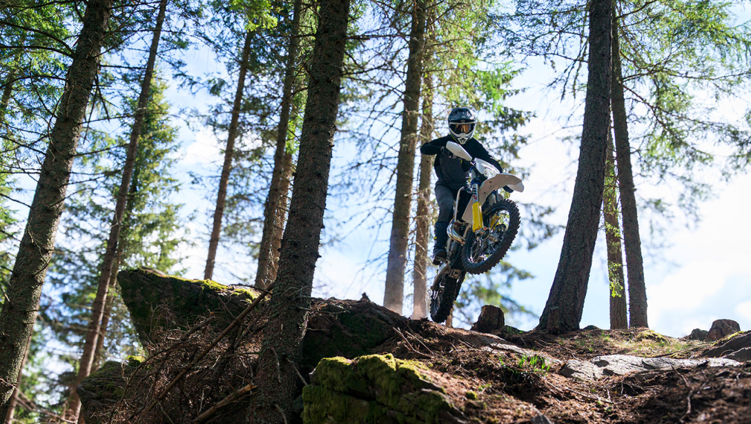Vue latérale de la Husqvarna TE 300 2026 sur un sentier d’enduro