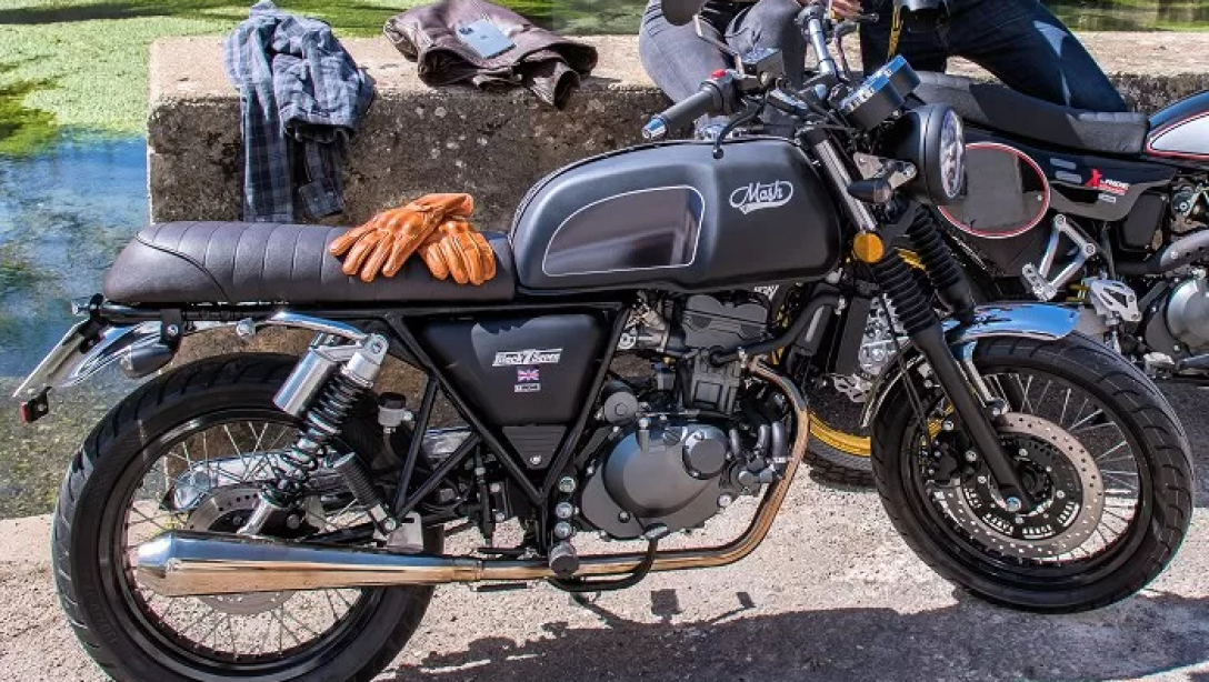 Vue latérale de la Mash Black Seven 125 2026 sur fond noir, mettant en avant son style café racer