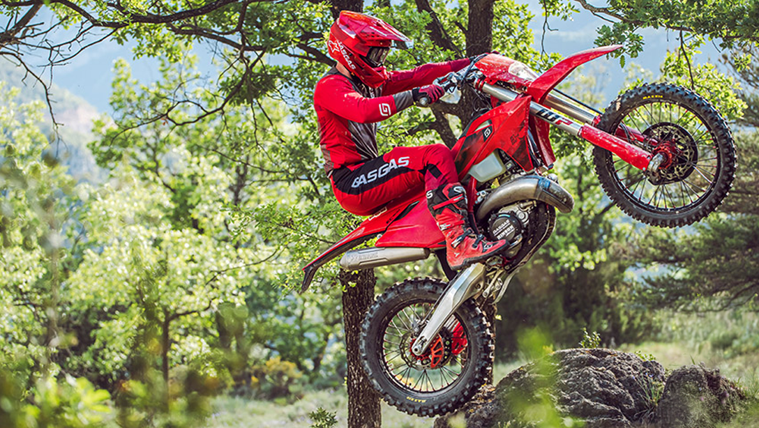Vue latérale dynamique de la GASGAS EC 300 2026 sur un terrain d’enduro.