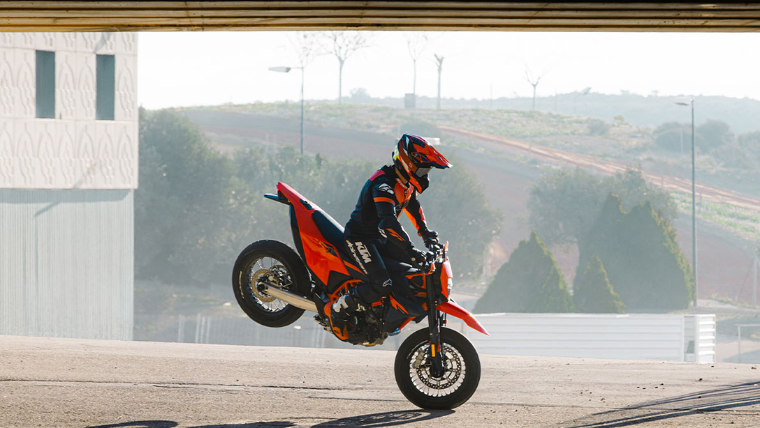 KTM 690 SMC R 2026 sur route de montagne, vue arrière