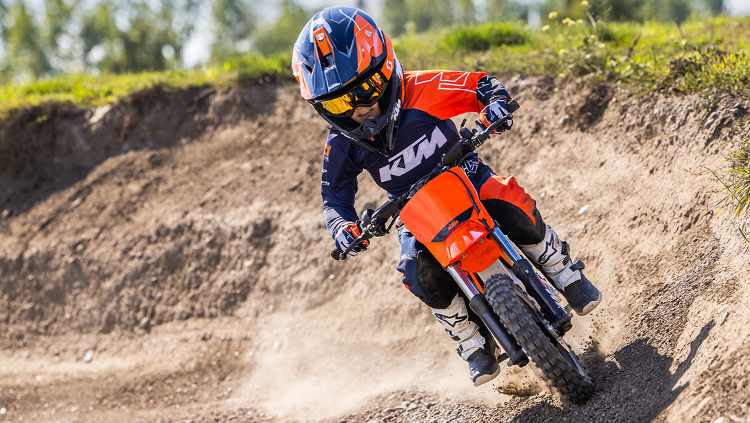 Enfant pilotant la KTM SX-E 2 2025 sur un terrain de cross