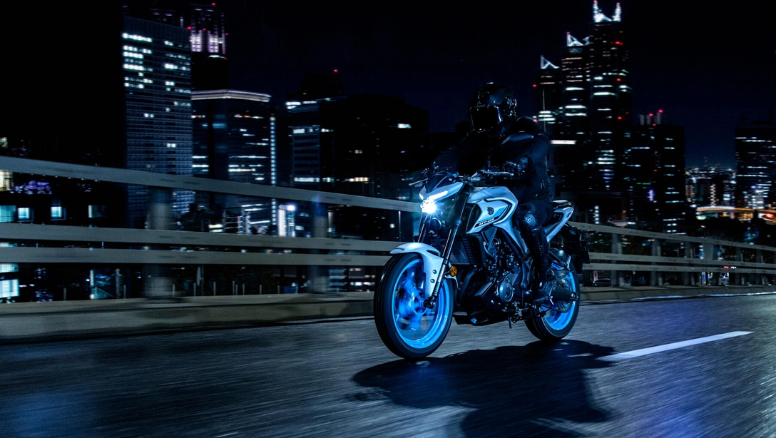 Vue avant de la Yamaha 2025 MT-03 sur fond sombre, mettant en valeur son design agressif