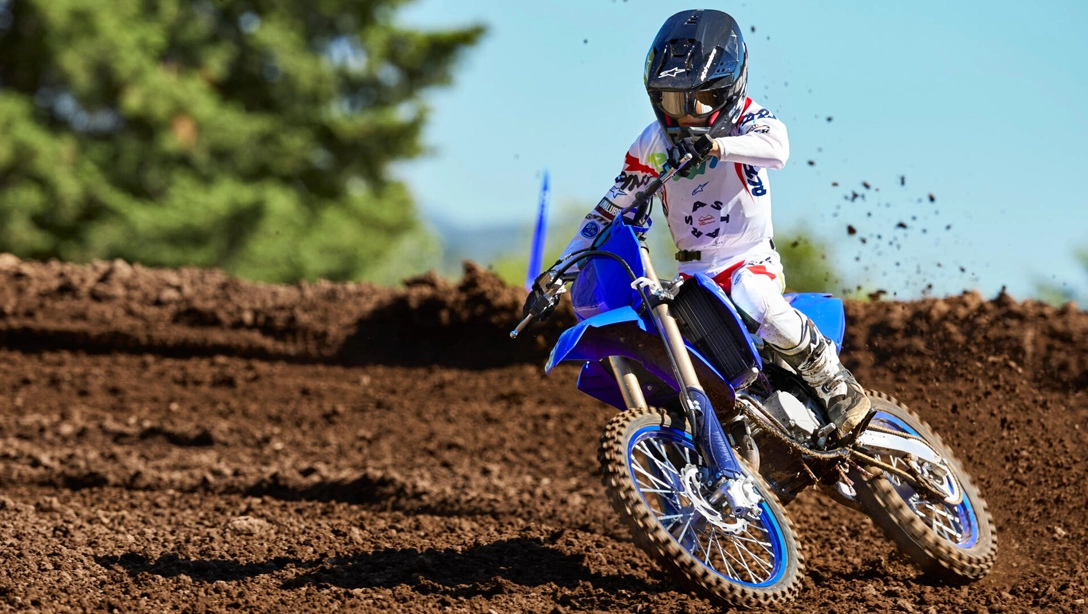 Vue latérale dynamique de la Yamaha 2025 YZ85 en action sur piste de motocross