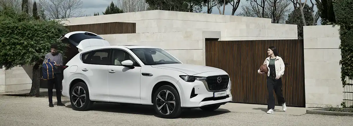 couple devant maison avec SUV Mazda CX-60 à Genève