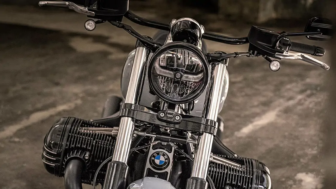 BMW R 18 stationnée devant un café, ambiance urbaine élégante.