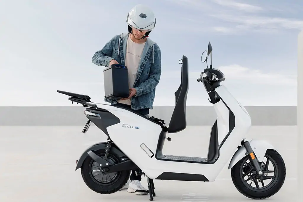Vue latérale du Honda EM1 e en stationnement urbain