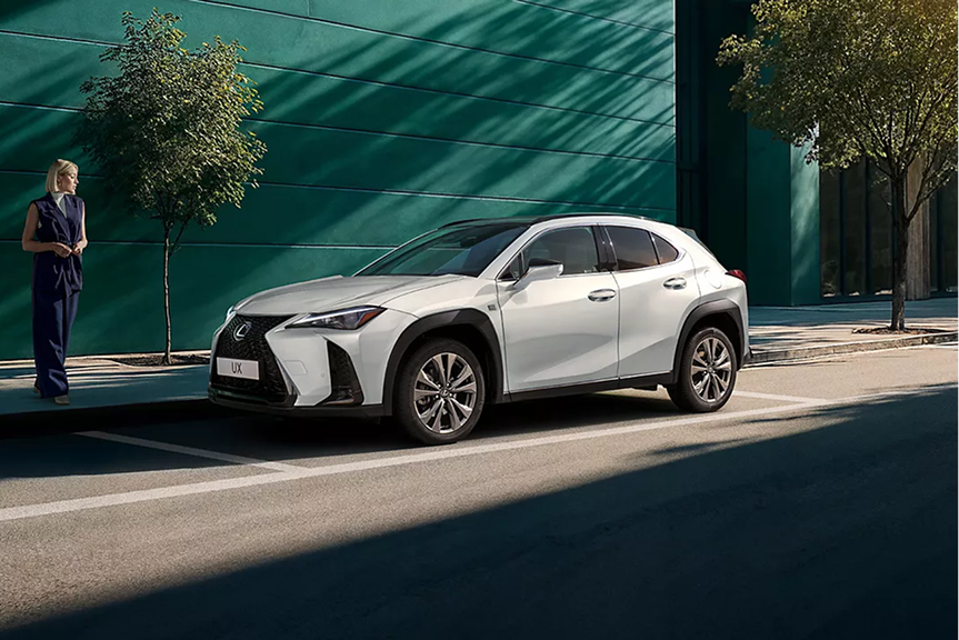 Vue avant du Lexus UX 2026 hybride en mouvement sur route urbaine